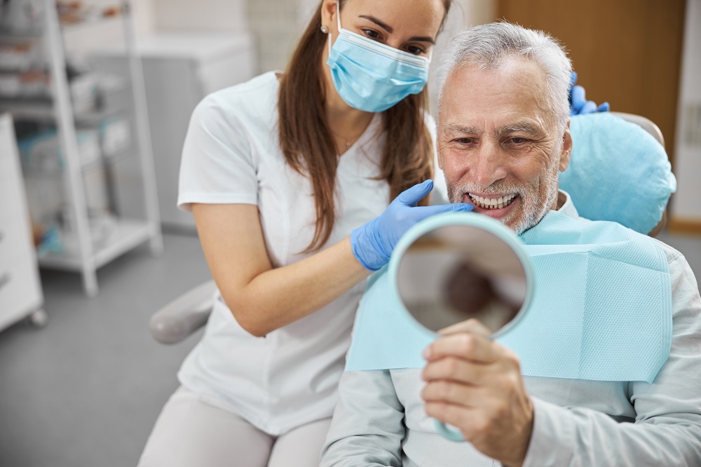 old man is smiling after getting dentures