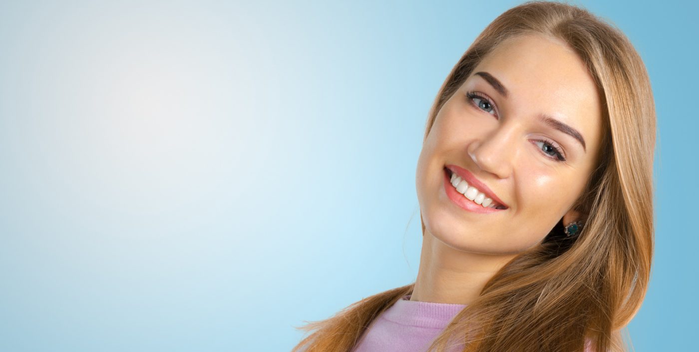 a woman smiles confidently after completing her dental treatment.
